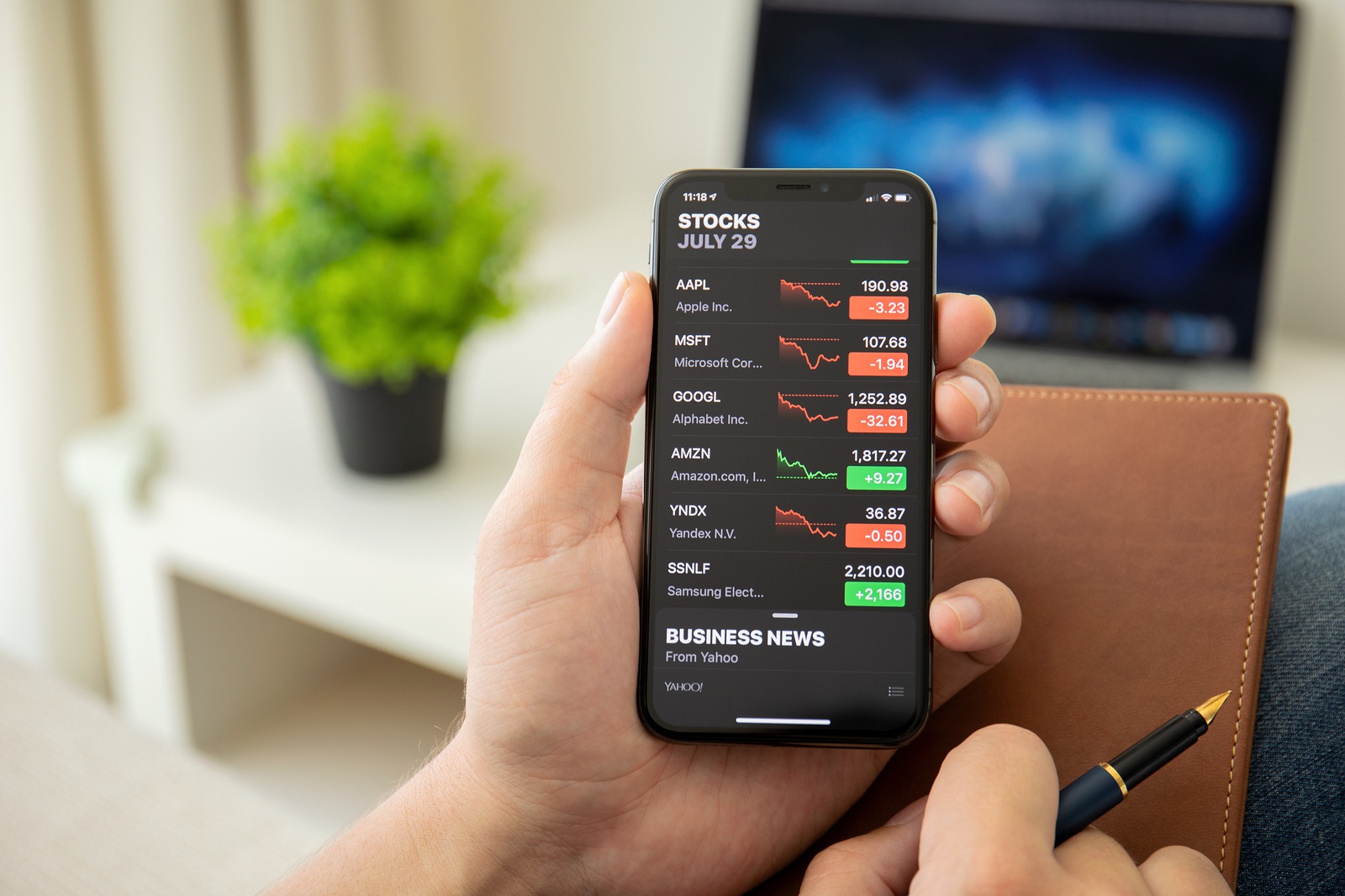 Alushta, Russia - July 29, 2018: Businessman holding iPhone X with application Stocks of Apple on the screen. iPhone ten was created and developed by the Apple inc.