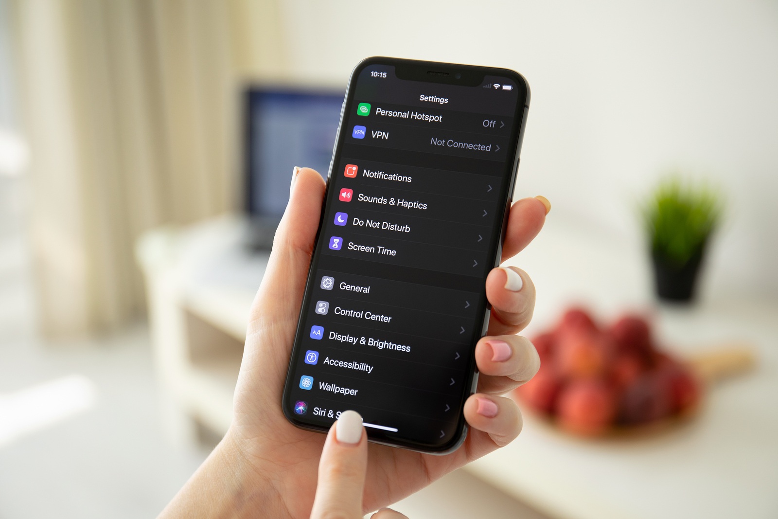 Anapa, Russia - July 21, 2019: Woman hand holding iPhone X with IOS 13 and Dark Mode settings. iPhone was created and developed by the Apple inc.