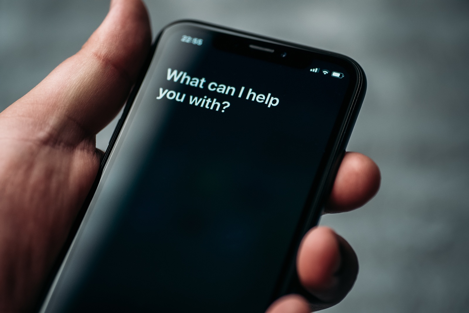 Moscow, Russia - Circa August 2019 : Siri - Apple voice digital assistant activated by voice in male hand and text on Iphone screen: What can I help you with? Voice mode of interaction with smartphone