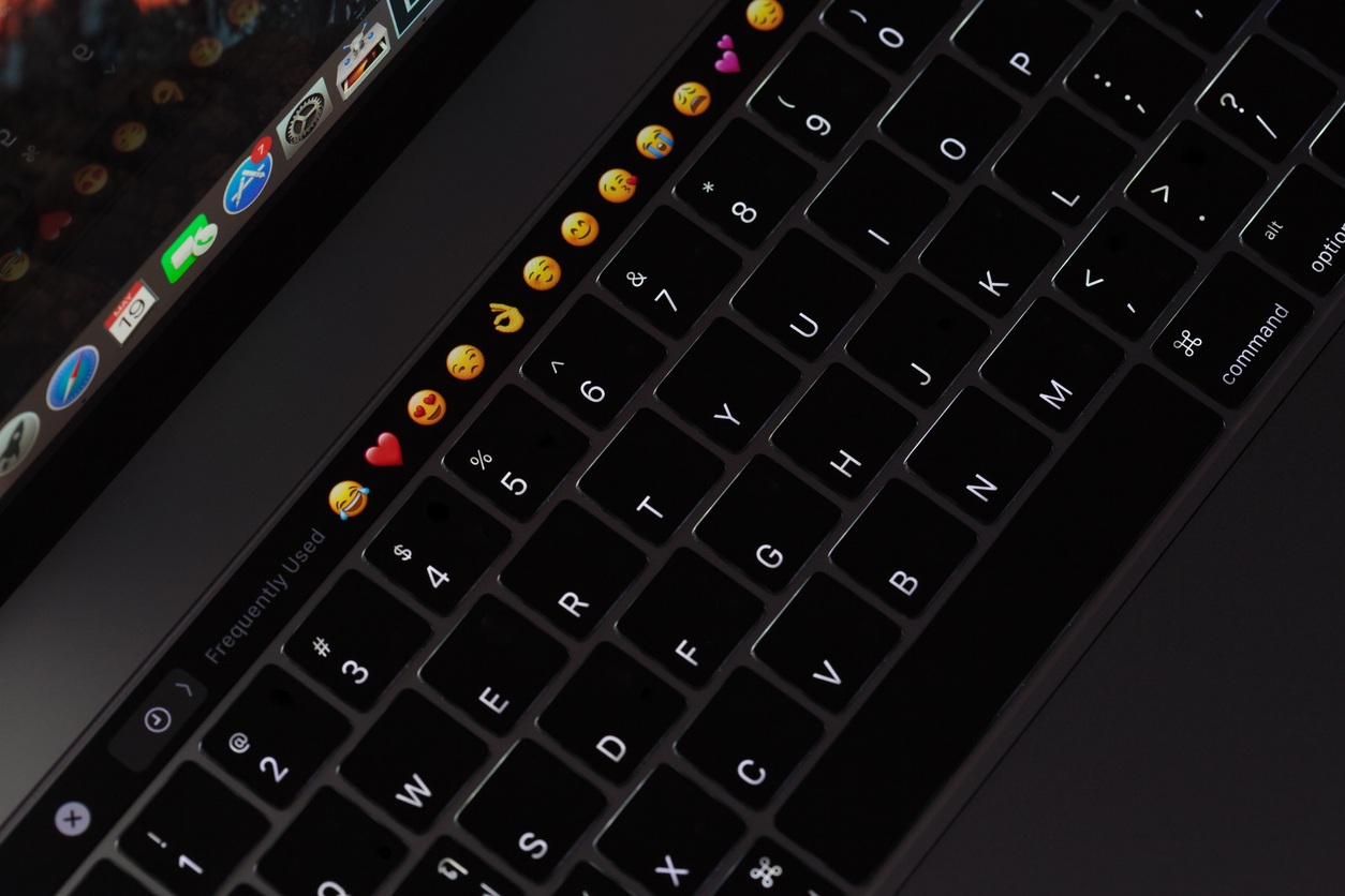 Bangkok, Thailand - May 19, 2017: Closeup new macbook pro 2016 keyboard showing illuminated and emoji on touch bar, macbook pro manufactured by apple Inc.