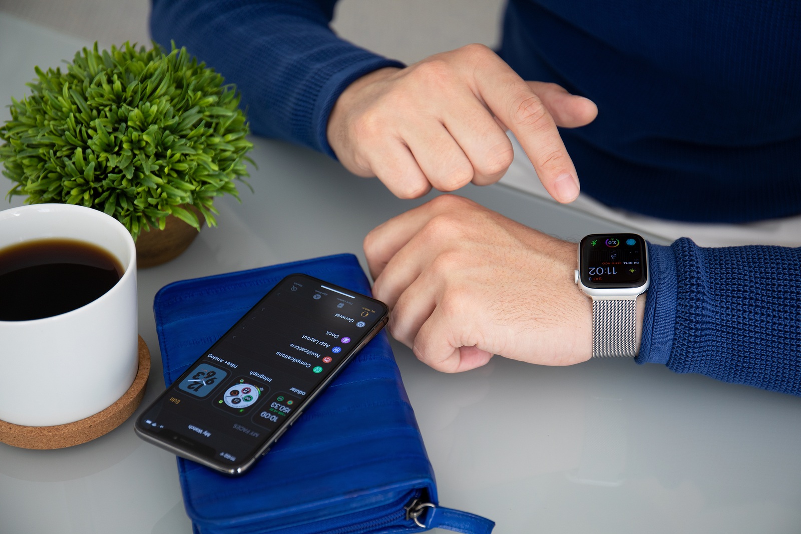 Alushta, Russia - November 3, 2018: Man hand with Apple Watch Series 4 and iPhone X on the table. Apple Watch was created and developed by the Apple inc.