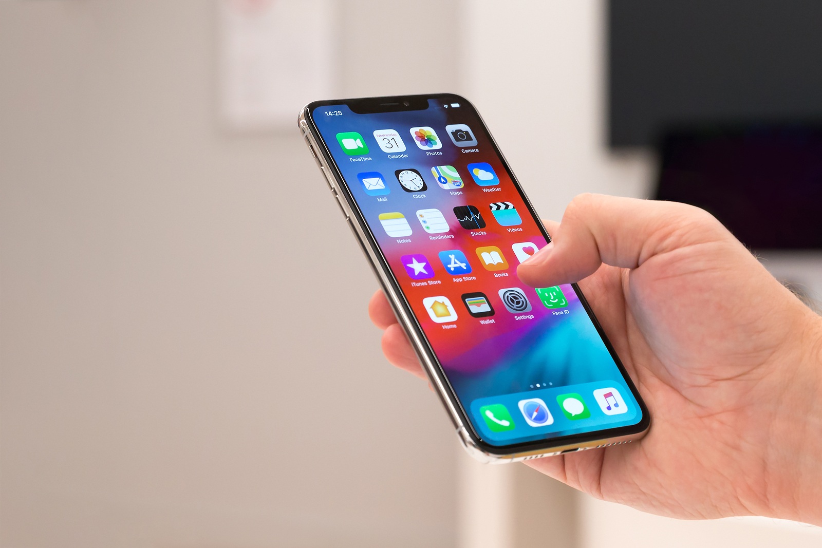 Belgrade, Serbia - October 31, 2018: New Apple iPhone XS mobile smartphone is displayed with apps on the screen in hand. Finger typing on digital gadget in electronic store.