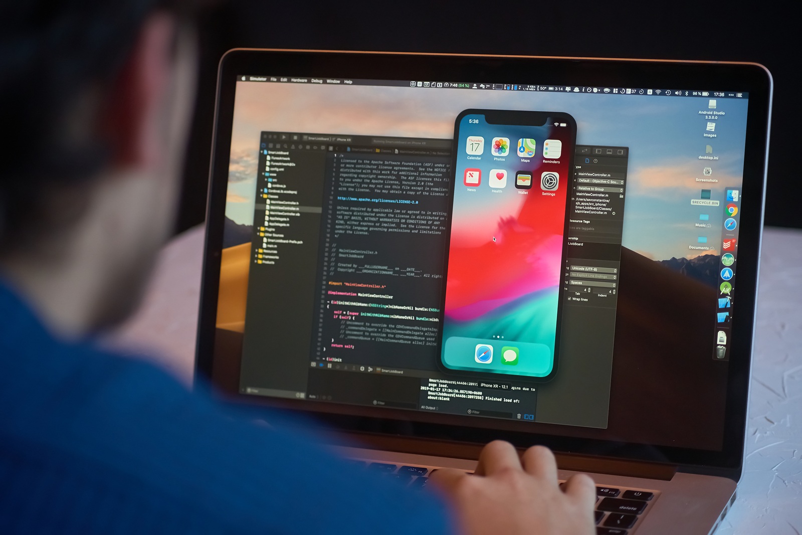 Bishkek, Kyrgyzstan - January 17, 2019: Man developer launches xcode software and ios simulator program to develop ios app on a MacBook