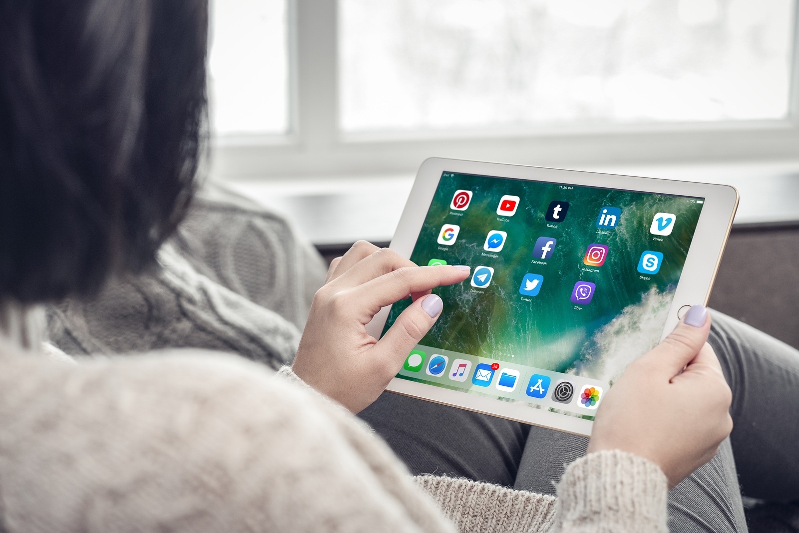 Kiev, Ukrain - February 10, 2018: Woman using social media apps on a brand new Apple iPad Pro Silver, 7th generation of the iPad, developed by Apple inc. and was announced on March 21, 2016