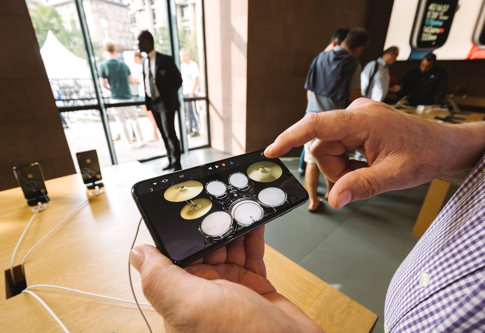 STRASBOURG, FRANCE - SEP 21, 2018: Senior man using drums in GarageBand music creation app on the iphone Xs Max during launch day in the Apple Store