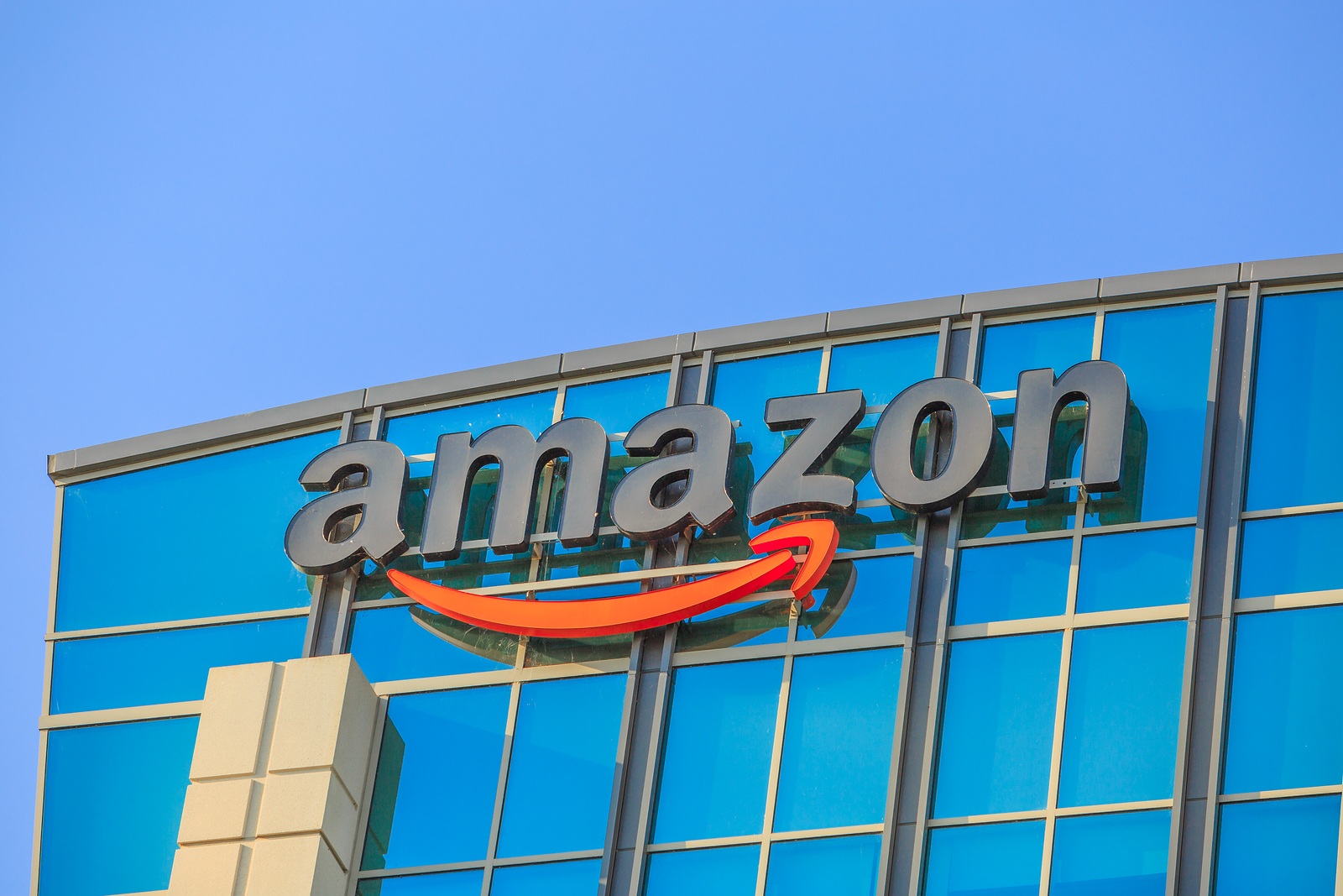 Sunnyvale, California, USA - August 13, 2018: closeup of Amazon Sign atop of glass building of Big Amazon campus in Silicon Valley. Amazon is leader in electronic commerce and cloud computing.