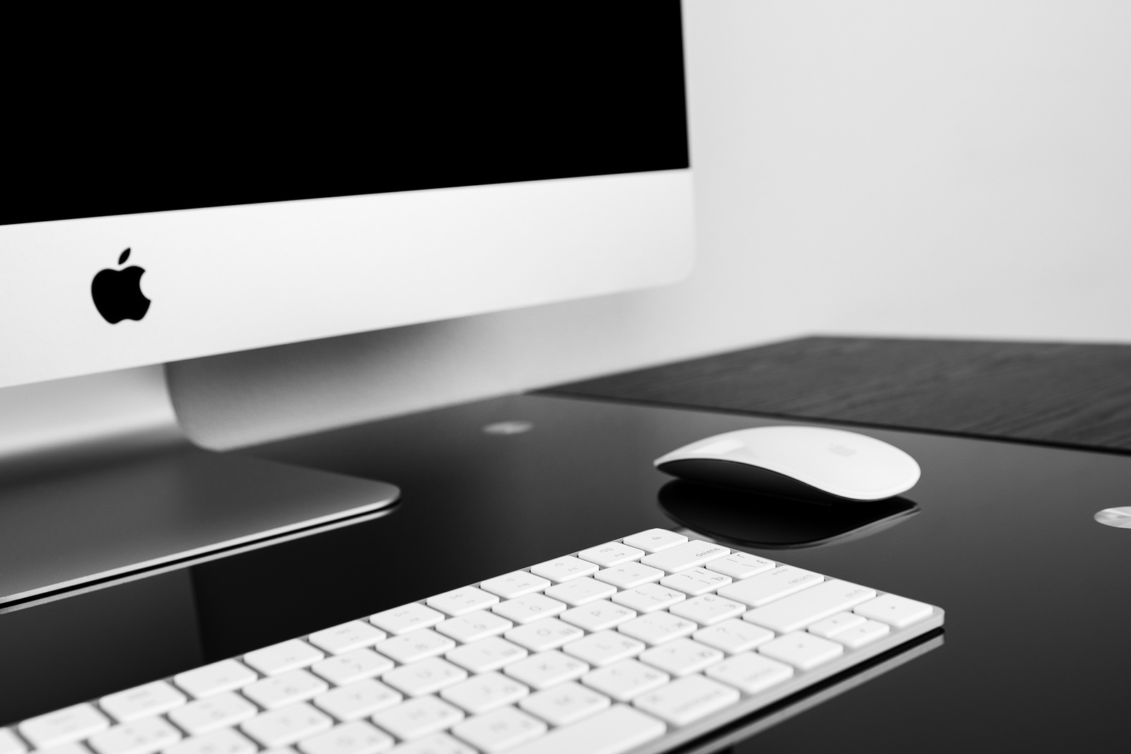 UKRAINE, RIVNE, October 11, 2018. Apple Computer iMac 27 retina display 5K keyboard and magic mouse on black table. Isolated on a white background