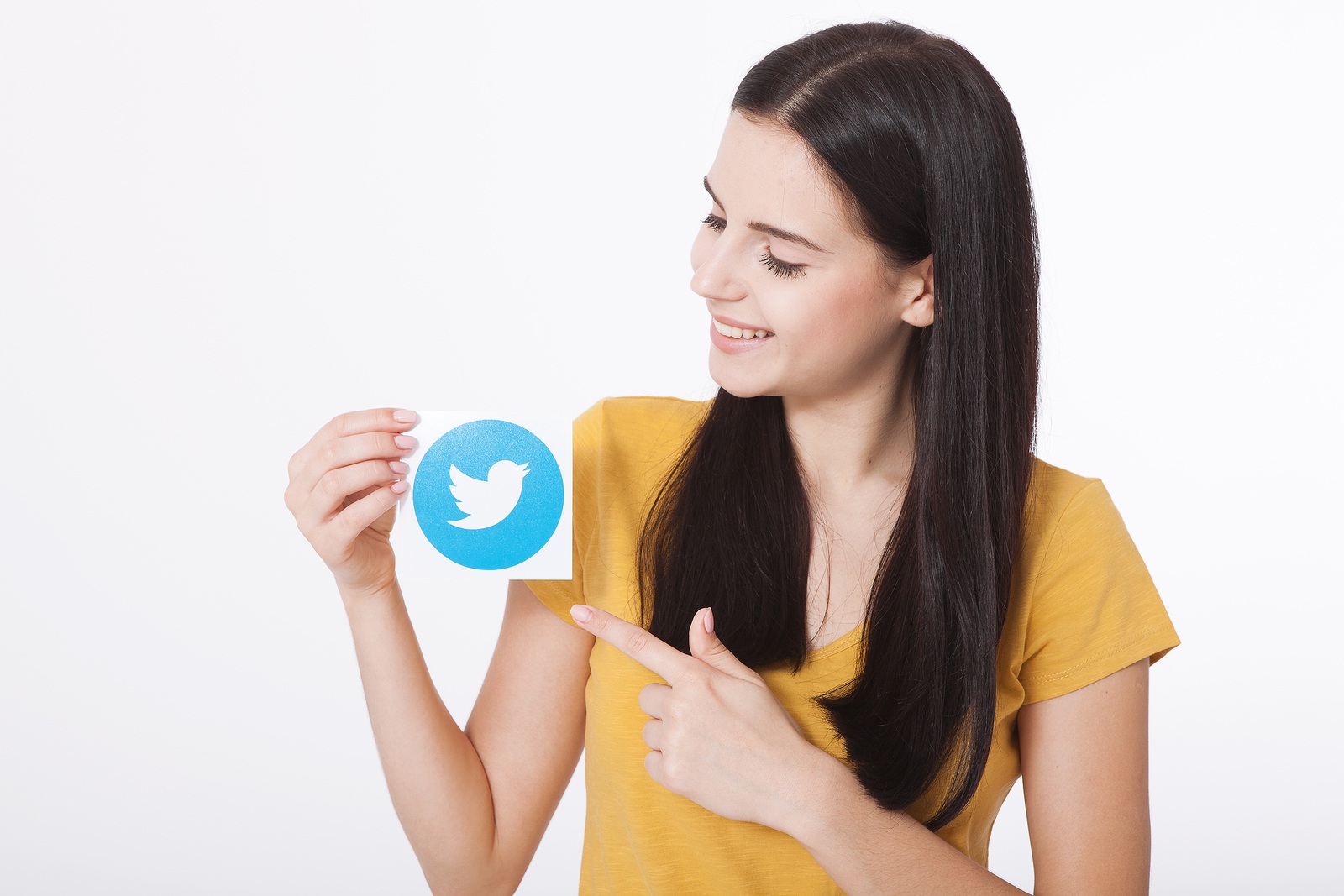 KIEV, UKRAINE - AUGUST 22, 2016: Woman hands holding Twitter logotype icoi bird printed paper close up. Twitter is an online social networking service that enables users to send and read short messages.