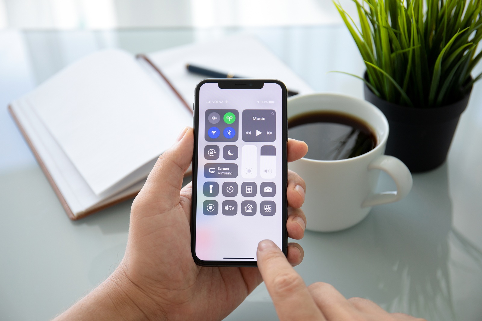 Alushta, Russia - July 27, 2018: Man hand holding iPhone X with home screen Control Center. iPhone 10 was created and developed by the Apple inc.