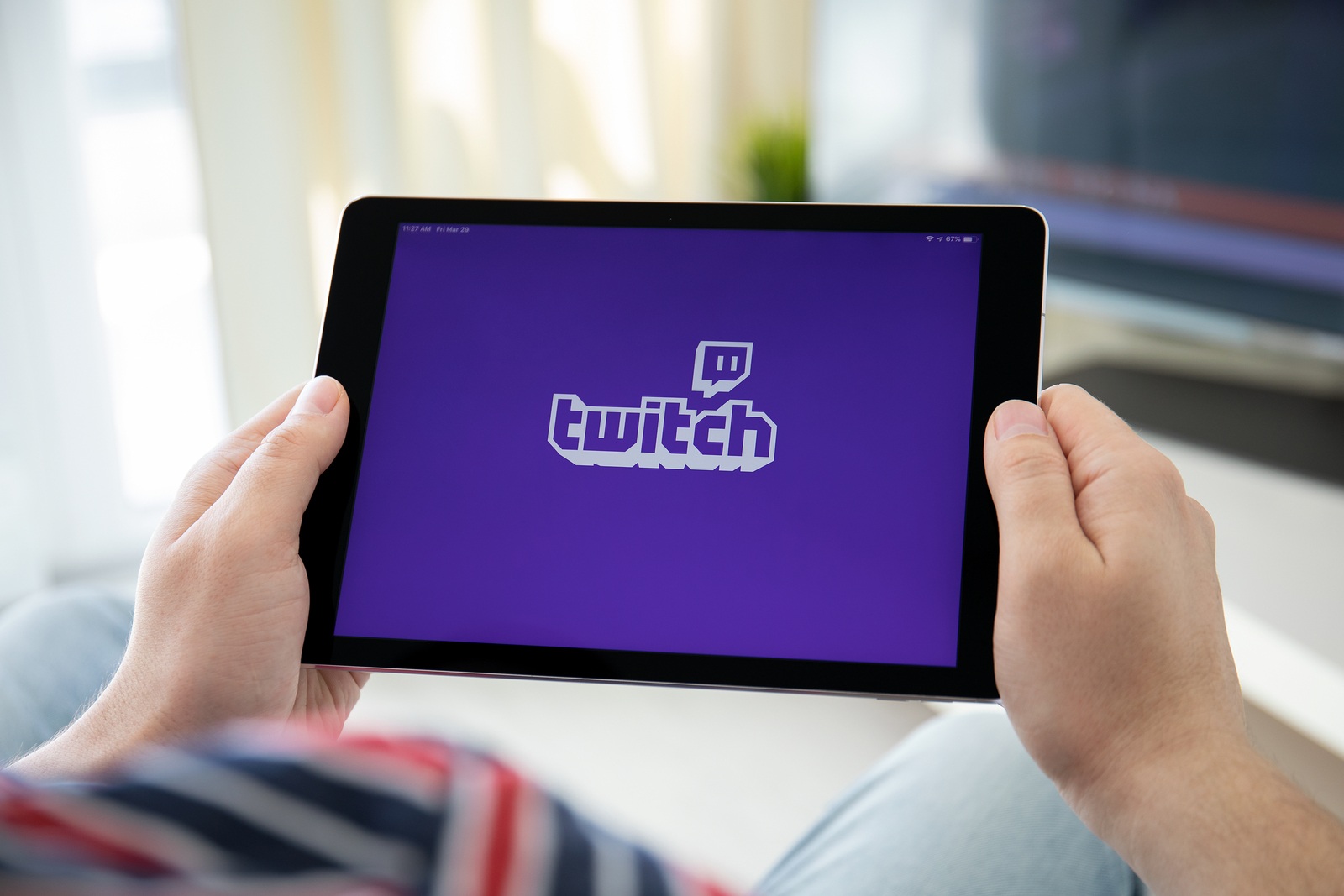 Anapa, Russia - March 29, 2019: Man holding iPad Pro with Twitch app provides streaming game and video on the screen.