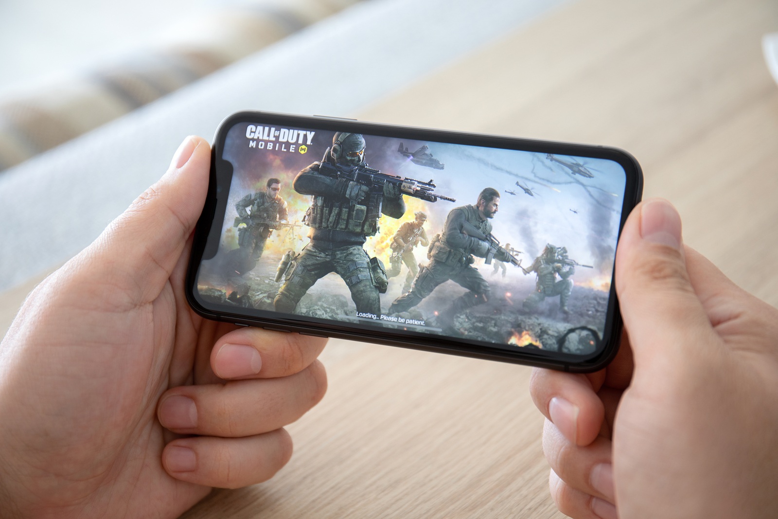 Anapa, Russia - October 2, 2019: Man hand holding iPhone 11 with game Call of Duty Mobile in the screen. Games Call of Duty was created by the Activision Publishing, inc.