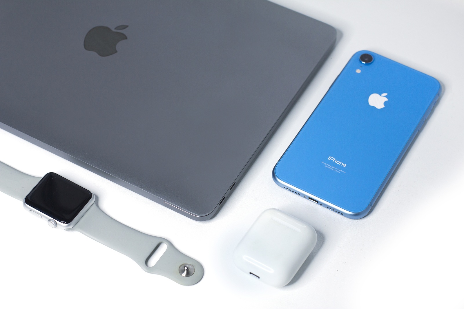 Saint-Petersburg/Russia - 09.09.2019: Still life, composition of new Apple gadgets, devices: Blue iPhone XR, wireless earphones Airpods, Apple Watch sport and MacBook Pro, Air space gray. Flat lay set