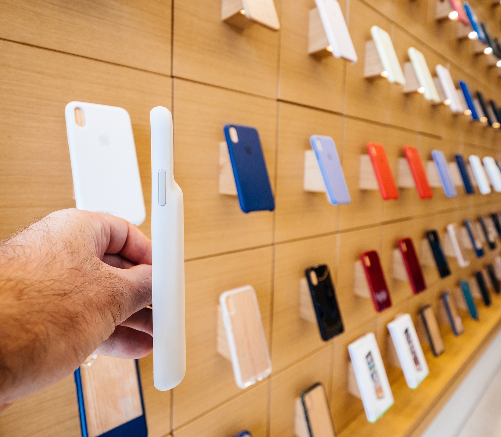 Paris, France - Circa 2019: Man POV holding Apple iPhone XS protection Smart Battery Case product displayed inside the new Apple Store Champs-Elysees largest French store