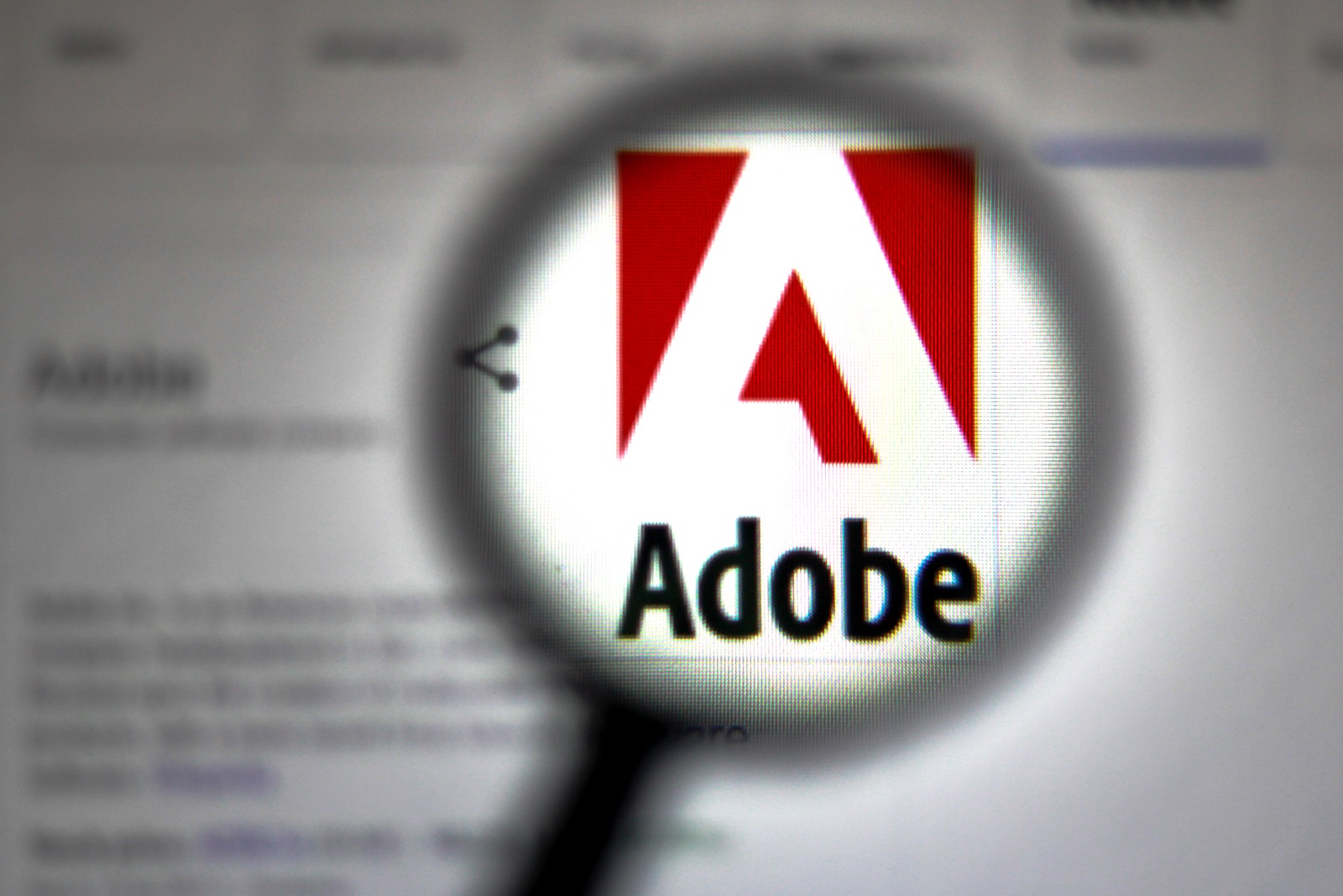 September 15, 2019, Brazil. In this photo illustration Adobe logo is seen through a magnifying glass.