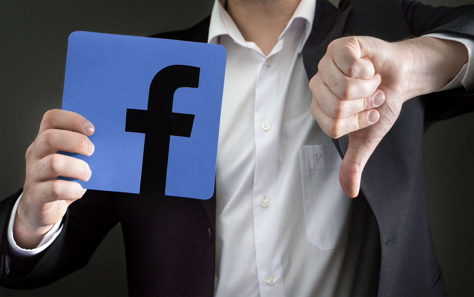 JYVASKYLA FINLAND - JUNE 13 2017: Man in a suit giving thumbs down with a cardboard Facebook logo. Facebook is a popular social media platform launched in 2004. Illustrative editorial.