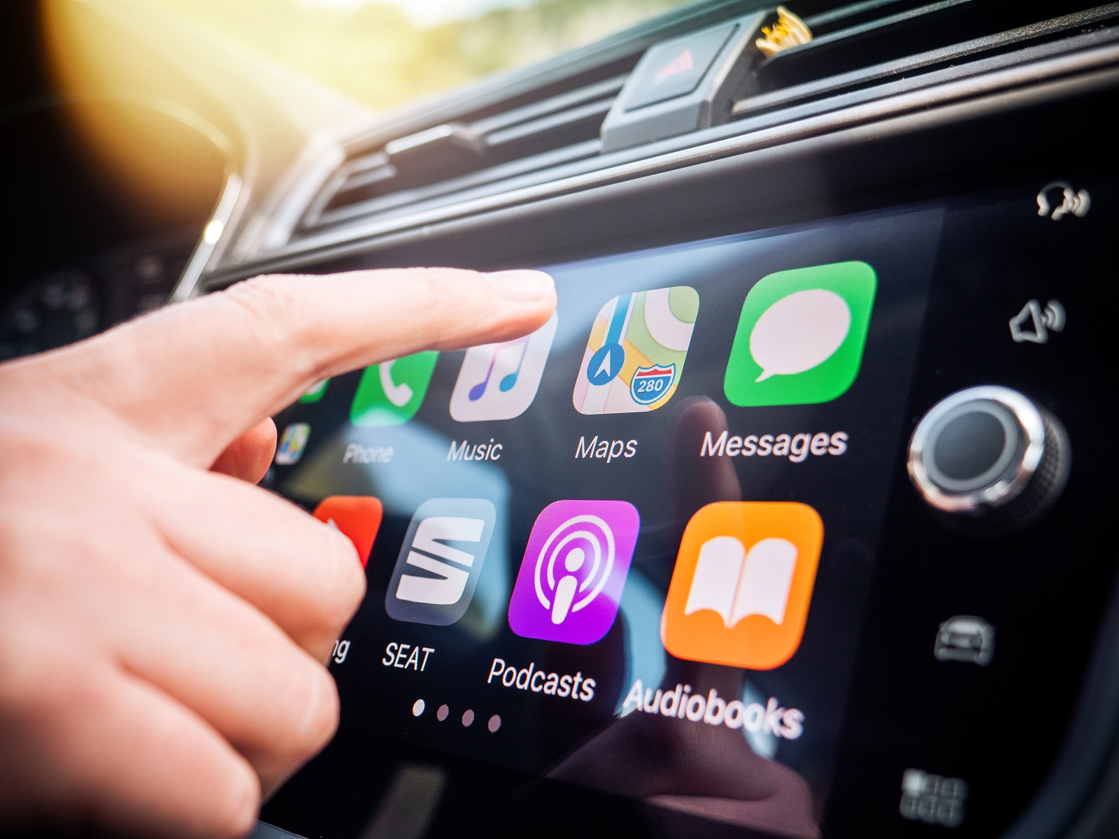 PALMA DE MALLORCA, SPAIN - MAY 10, 2018: Woman pressing Apple Maps button on the Apple CarPlay main screen in modern car dashboard during driving on Spanish holiday highway - large digital display screen