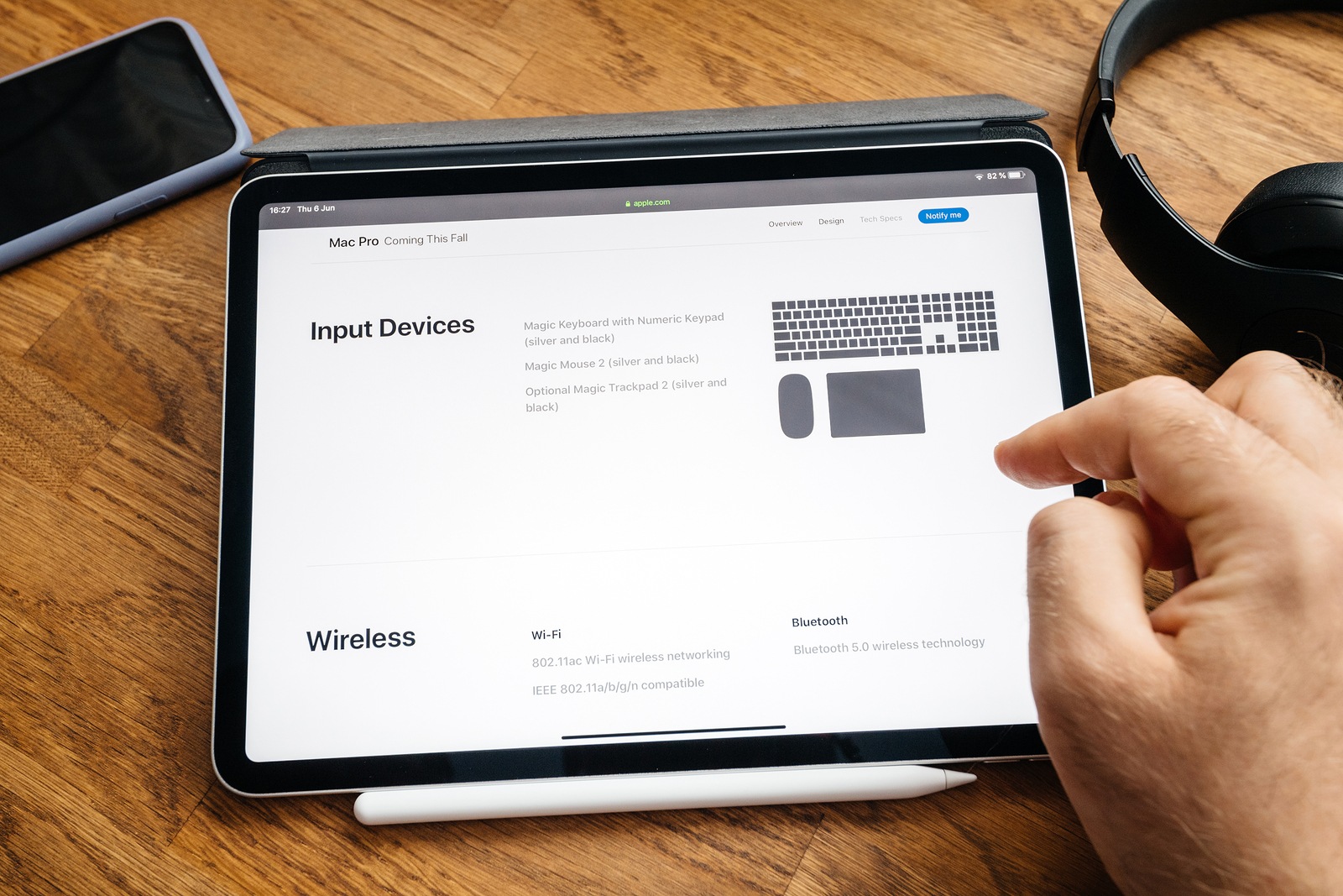 Paris, France - Jun 6, 2019: Man reading on Apple iPad Pro tablet about latest announcement of at Developers Conference WWDC - showing the Mac Pro workstation with acceosries and wireless wi-fi