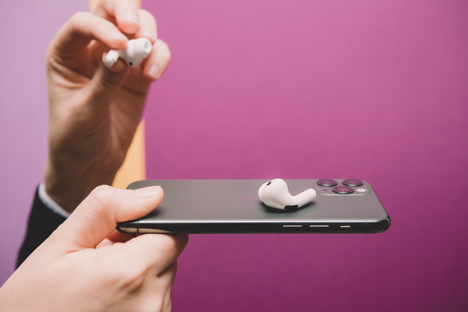 Paris, France - Oct 30, 2019: Woman hands holding presenting new Apple Computers AirPods Pro headphones with Active Noise Cancellation for immersive sound - placed on new iphone 11 Pro smartphone