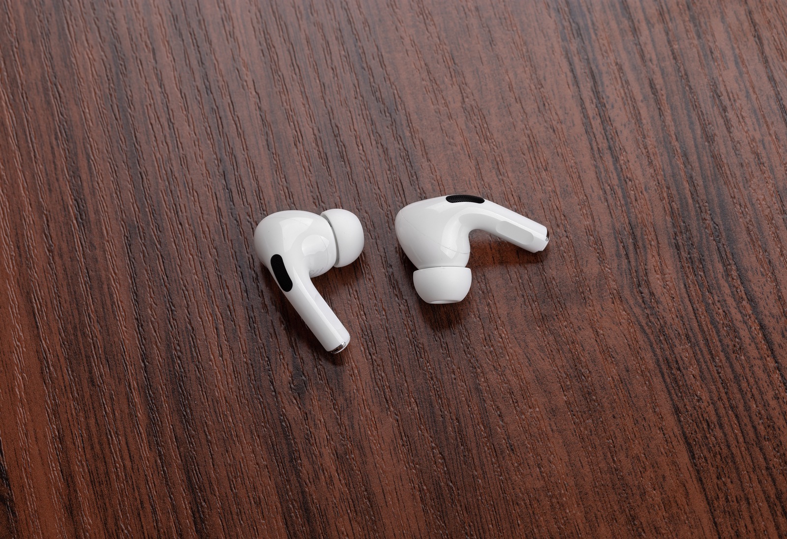 Rostov-on-Don, Russia - December 2019. Apple AirPods Pro on a wooden table. Wireless headphones close-up.