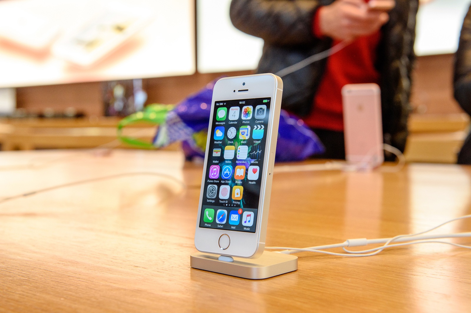 PARIS FRANCE - APR 4 2016: People testing new iPhone with the Apple iPhone SE in docking station during the sales launch of the latest Apple Inc. smartphone and iPad Pro at the Apple store in Paris France