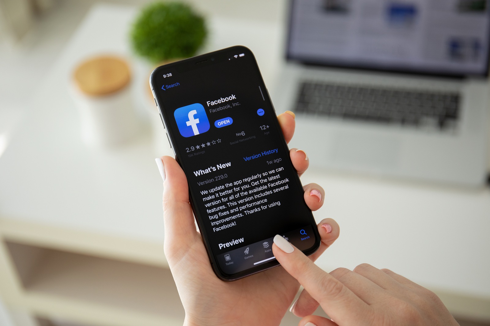 Anapa, Russia - July 22, 2019: Woman holding iPhone X with social networking service Facebook on the screen. iPhone was created and developed by the Apple inc.