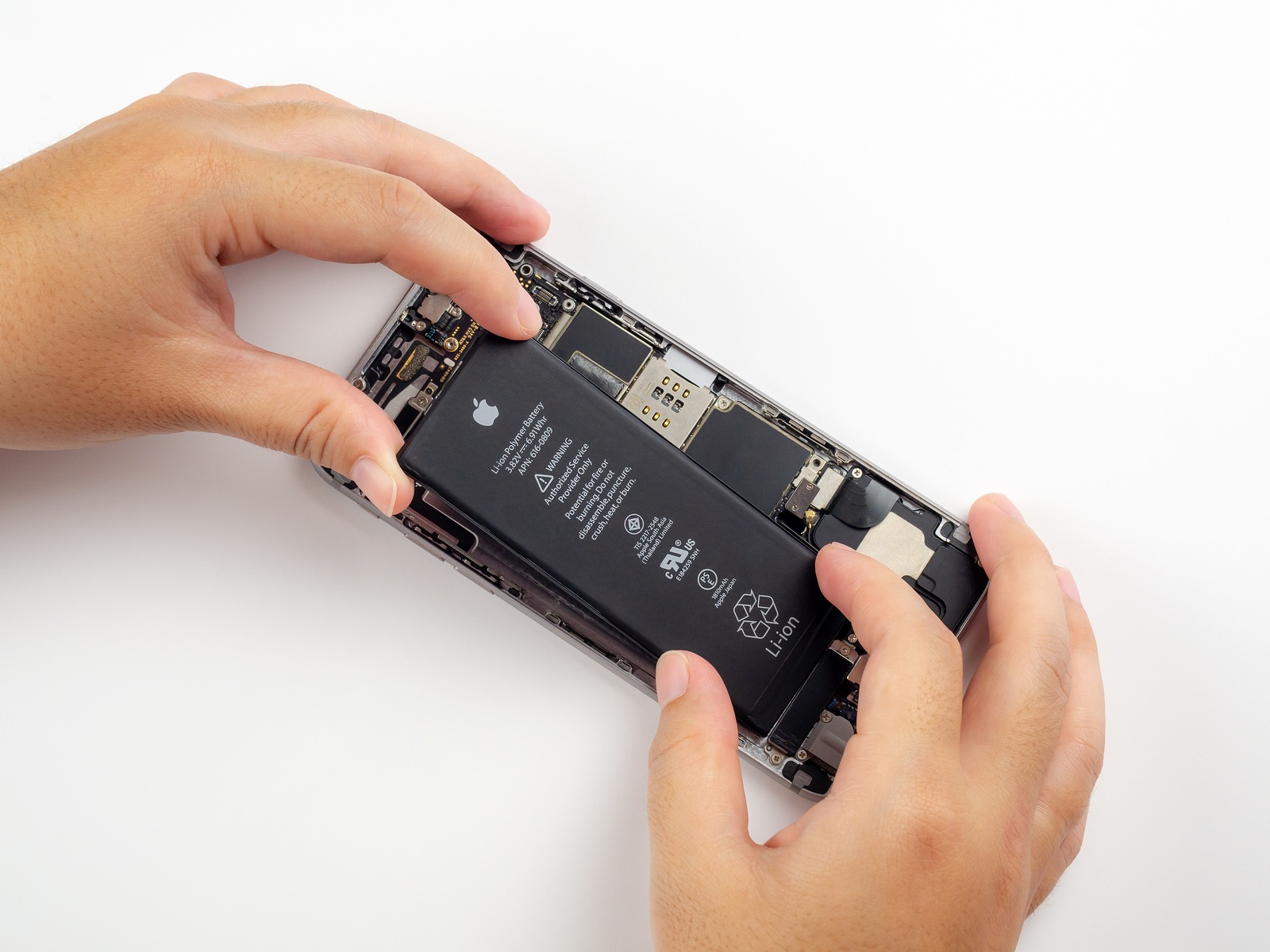 Chiang Rai, Thailand: September 13, 2018 - Close-up image of Technician hands tried to remove, take of, change or replace Apple iPhone 6 battery degenerate or damage.