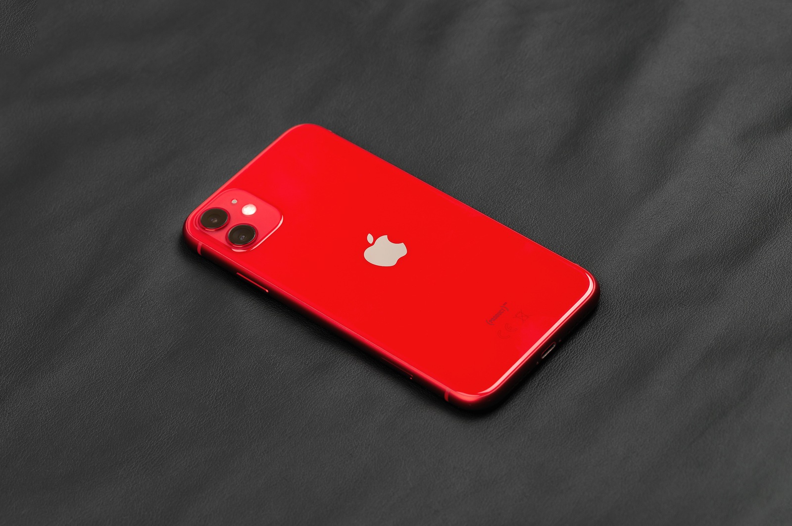 Rostov-on-Don, Russia - December 2019. Apple iPhone 11 PRODUCT RED on a black leather surface. New smartphone from the company Apple close-up.