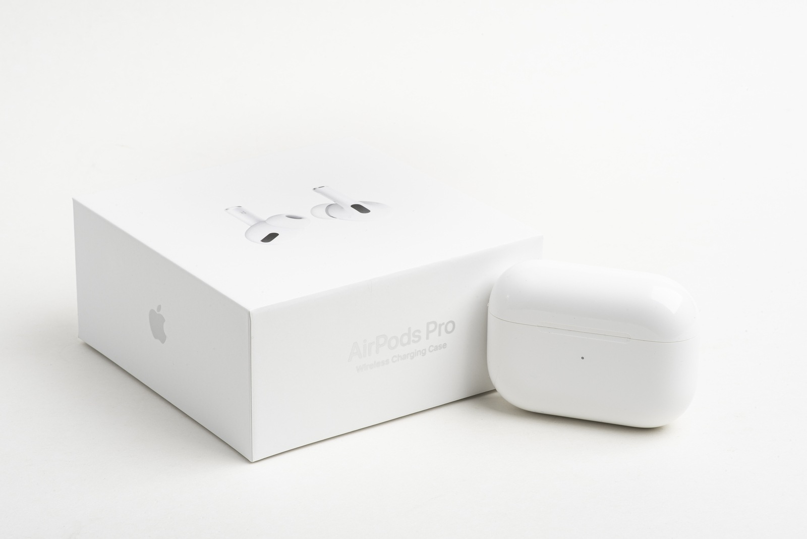 Vidalia, Georgia / USA - December 14, 2019 - A studio product shot of the white packaging box with the closed white charging case if Apple AirPods Pro set on a plain light color background.