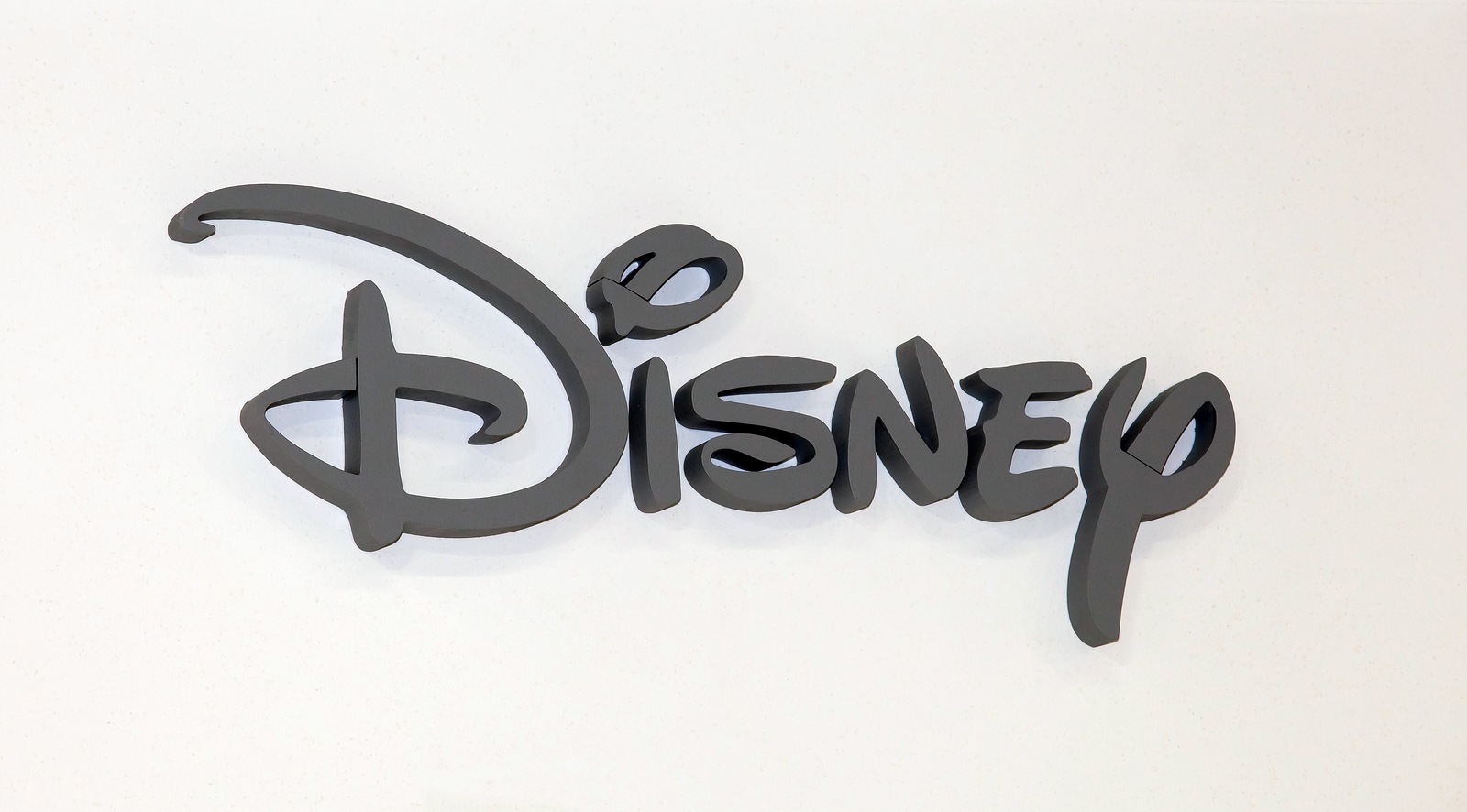 Moscow, Russia - March, 2015: Disney company logo sign. Grey plastic letters on the white wall