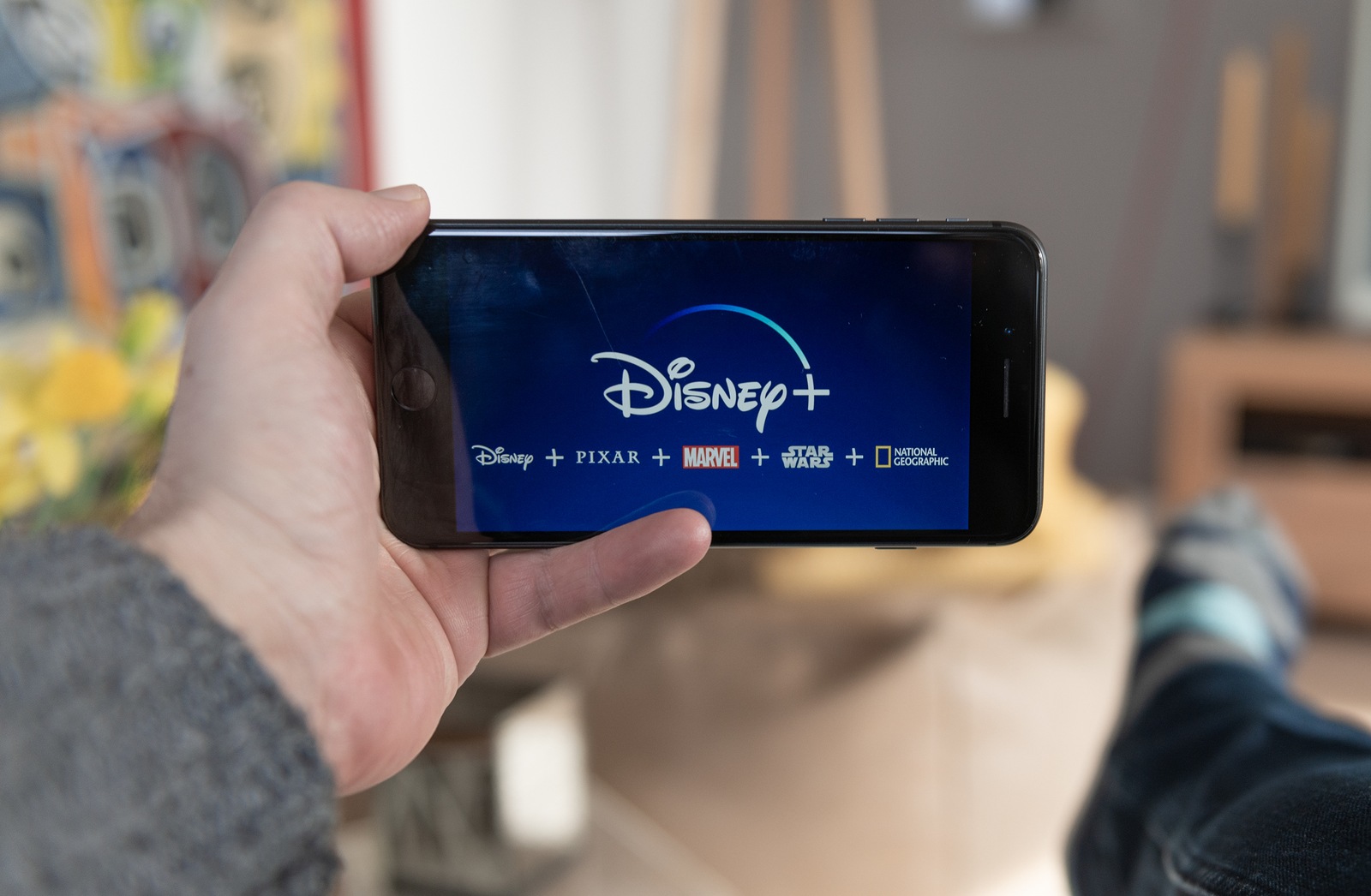 Amsterdam, The Netherlands, 02/03/2020, Disney+ startscreen on  mobile phone. Disney+ online video, content streaming subscription service. Man holds his smartphone up and looks at disney plus