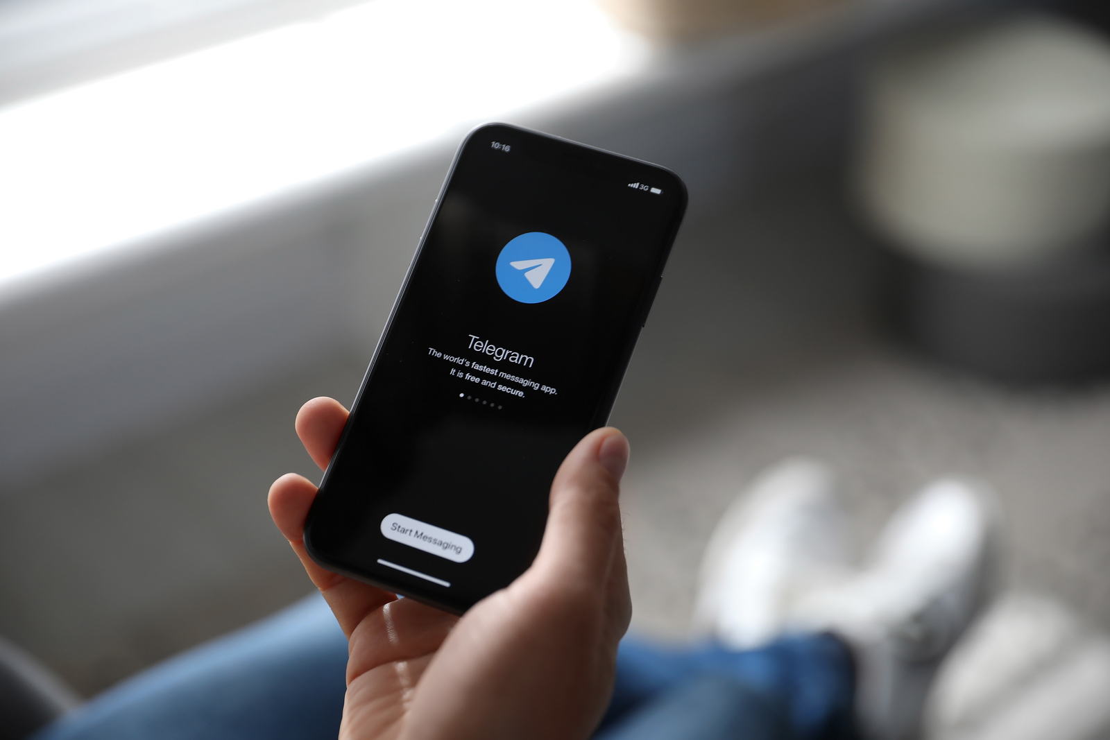 MYKOLAIV, UKRAINE - MARCH 16, 2020: Man holding iPhone 11 with Telegram app on screen indoors, closeup