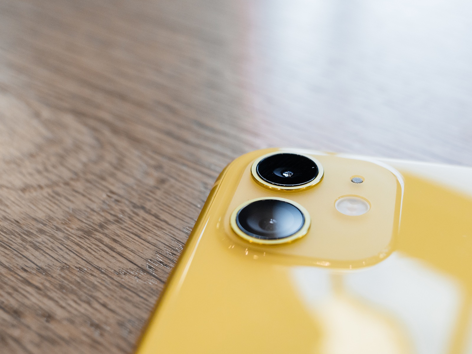 Paris, France - Sep 20, 2019: Close-up of the new iPhone 11 dual camera system on the wooden table It is the thirteenth generation lower-priced iPhone, succeeding the iPhone XR