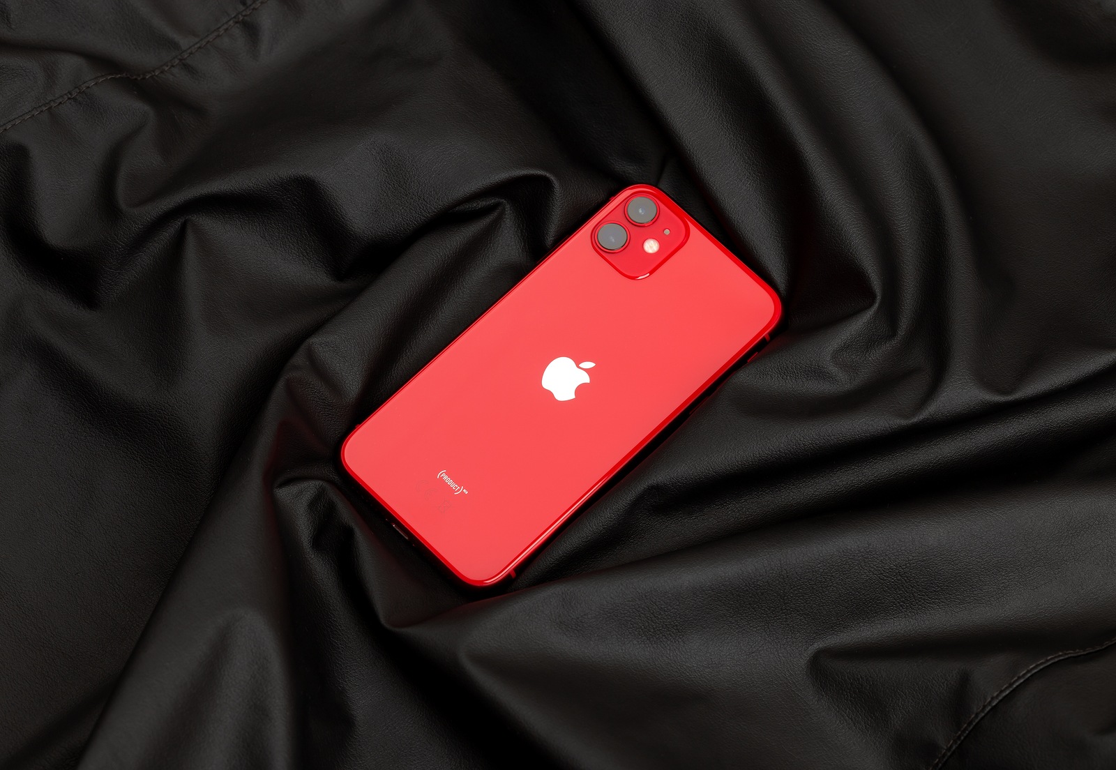 Rostov-on-Don, Russia - December 2019. Apple iPhone 11 PRODUCT RED on a black leather surface. New smartphone from the company Apple close-up.