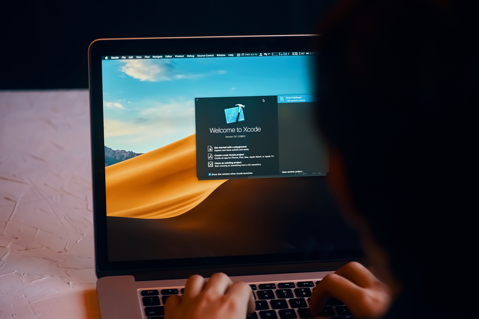 Bishkek, Kyrgyzstan - January 17, 2019: Man developer launches xcode software to develop ios app on a MacBook