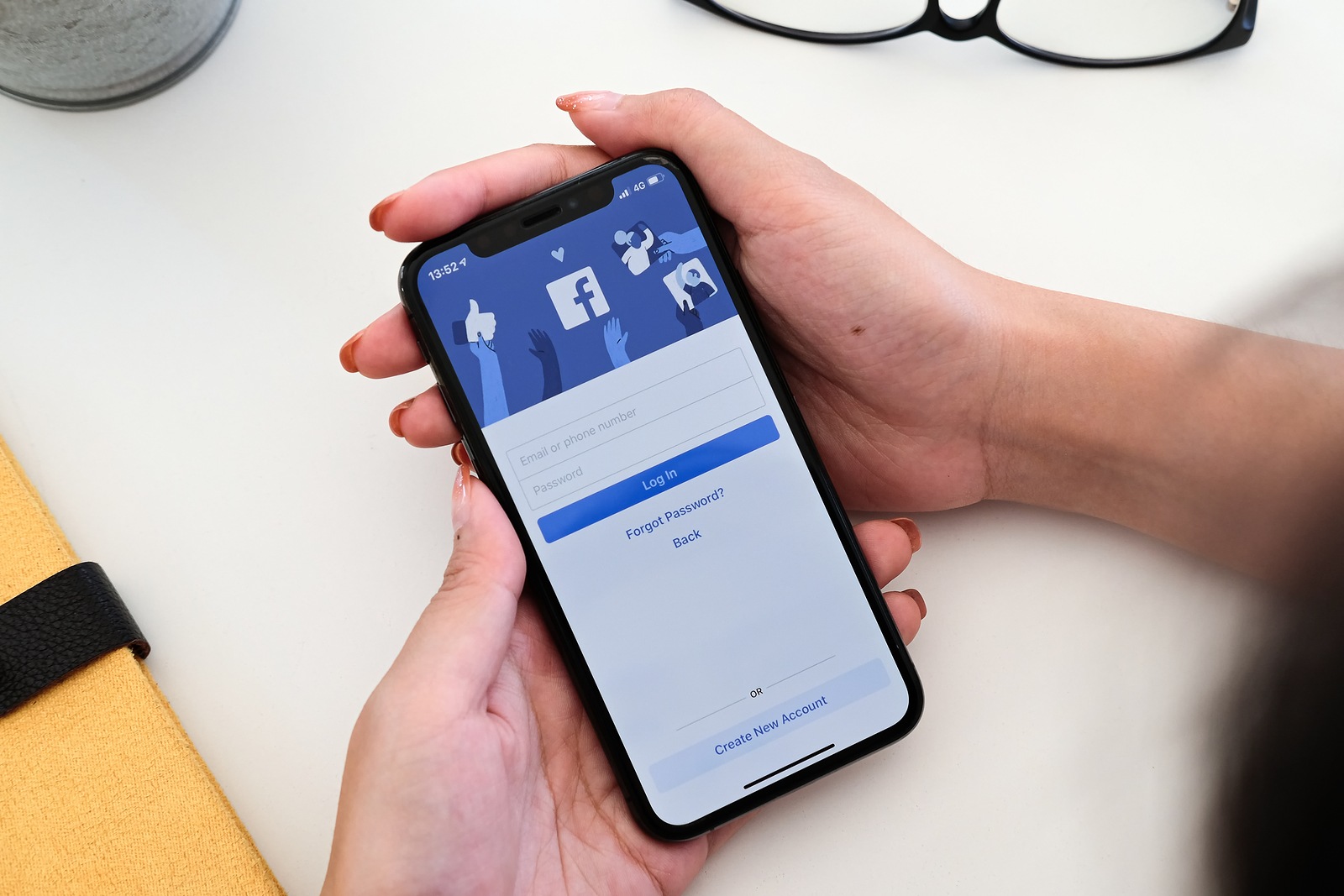 CHIANG MAI ,THAILAND - JAN 19, 2020 : Woman hand holding iPhone XS to use facebook with new login screen.Facebook is a largest social network and most popular social networking site in the world.