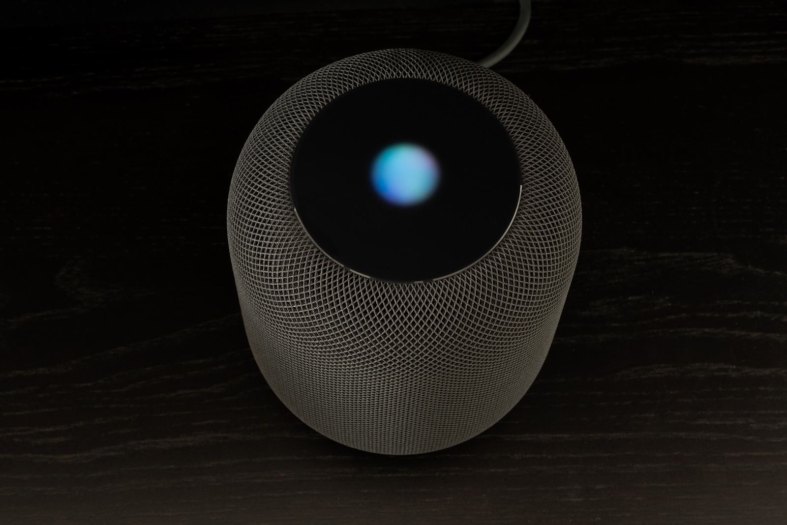 Ostfildern, Germany - June 26, 2018: Using an Apple HomePod speaker - the smart speaker is reacting to voice input and signalling its attention by the changing lights