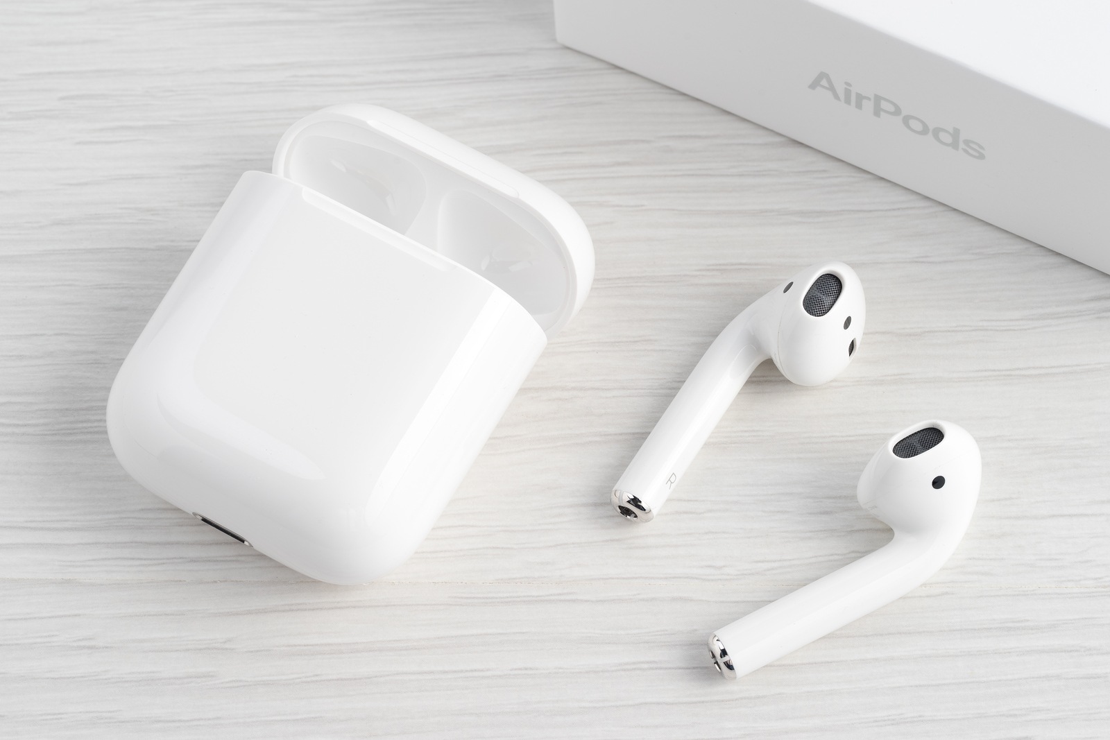 UFA RUSSIA - OCTOBER 20 2017: AirPods wireless headphones developed by Apple Inc. AirPods are on the table and box.