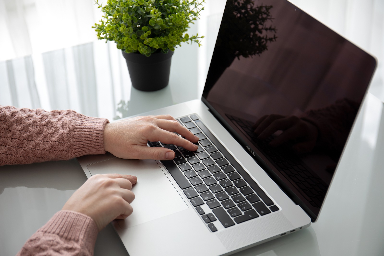 Anapa, Russia - February 22, 2020: Backgrounds Black on screen MacBook Pro 16 in the table woman hand. MacBook Pro 16 was created and developed by the Apple inc.