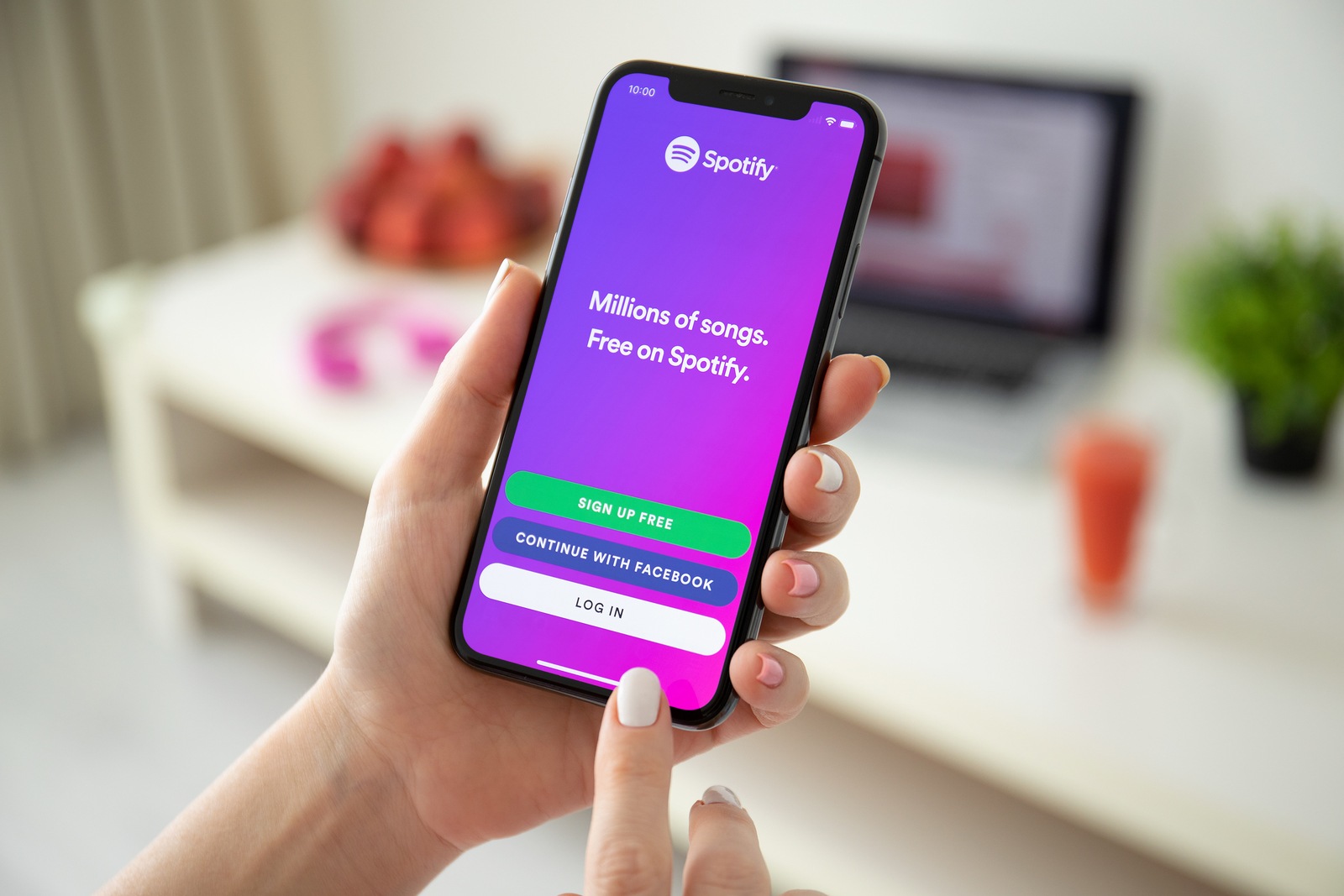 Anapa, Russia - July 21, 2019: Woman holding iPhone X with music service Spotify on the screen. iPhone was created and developed by the Apple inc.