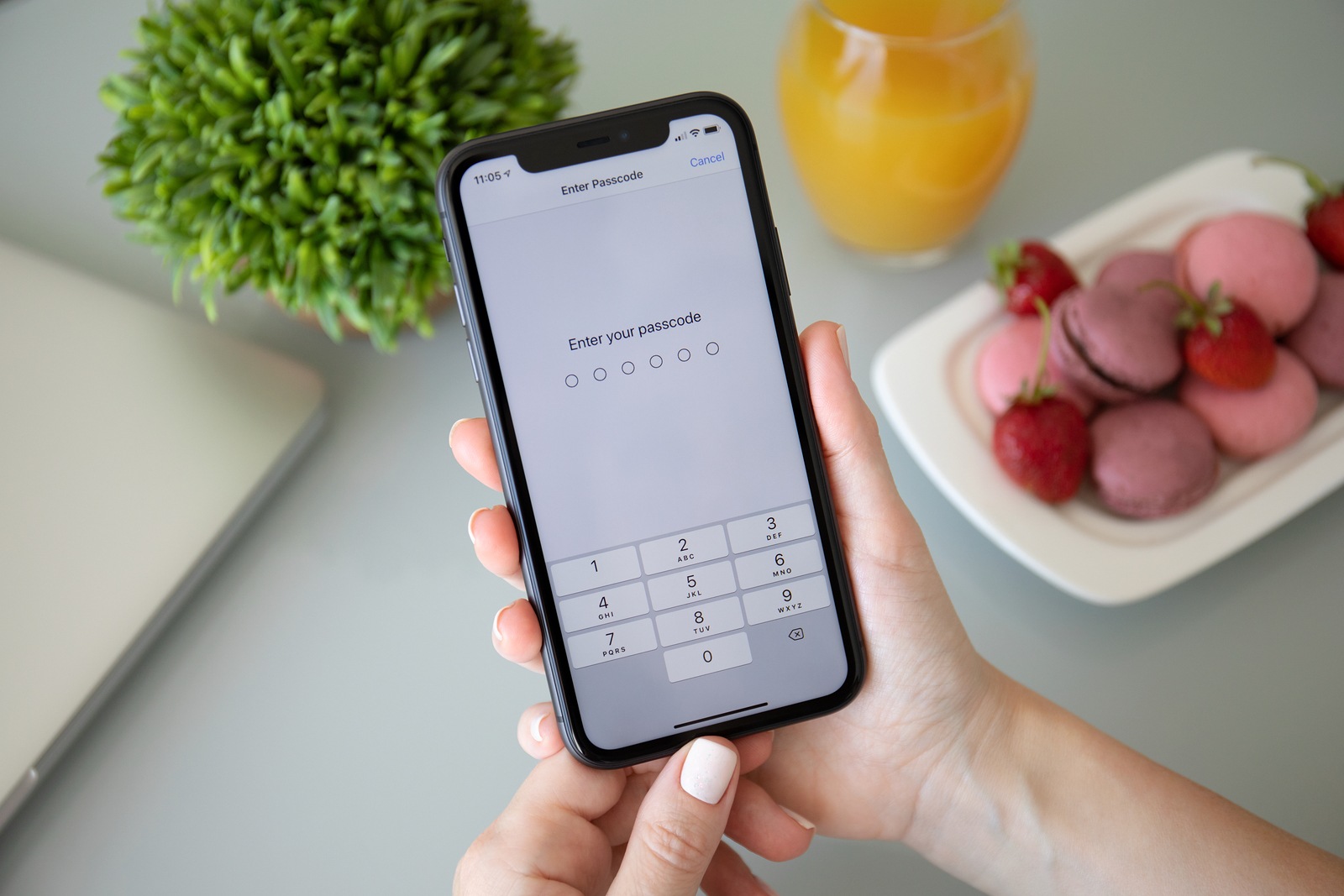 Anapa, Russia - October 3, 2019: Woman hand holding iPhone 11 with Pin code on the screen. iPhone 11 was created and developed by the Apple inc.