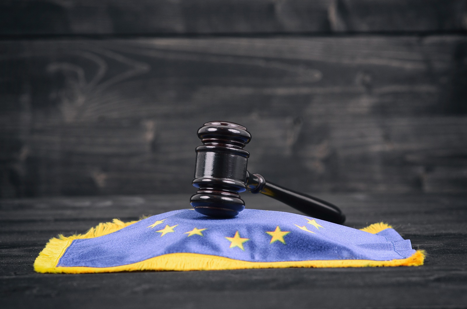 Law and Justice, Legality concept, Judge Gavel and European Union flag on a black wooden background.