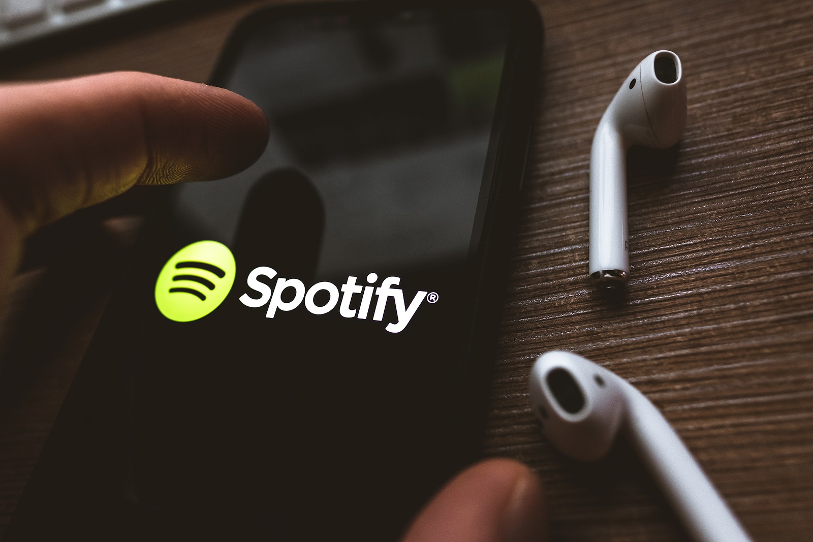 iPhone X and AirPods with screen shot of Spotify app . High quality photo.