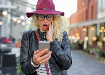 Woman looking at her phone in shock