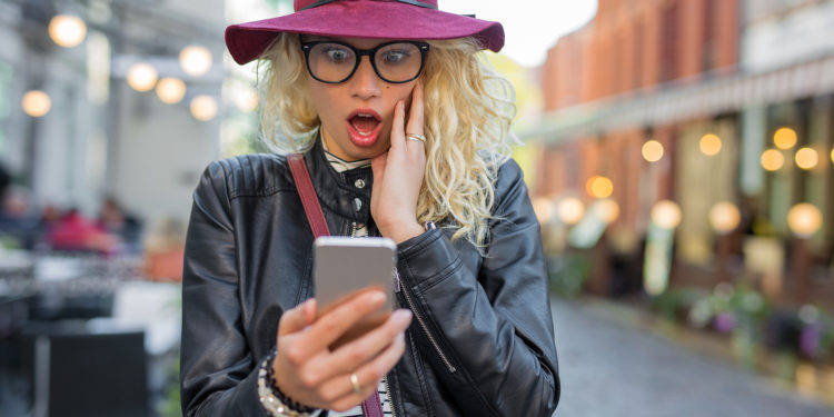 Woman looking at her phone in shock