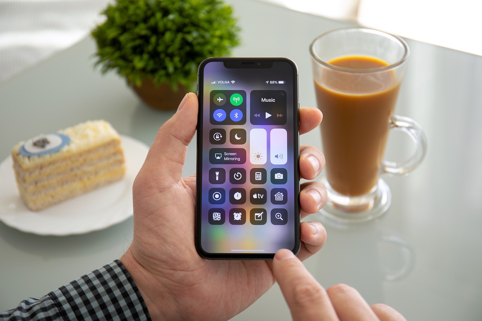 Alushta, Russia - November 6, 2018: Man hand holding iPhone X with home screen Control Center. iPhone 10 was created and developed by the Apple inc.