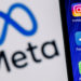 Kazan, Russia - Oct 28, 2021: Facebook changes its name to Meta. Smartphone with Facebook, Whatsapp and Instagram app icon on the background of Meta logo.